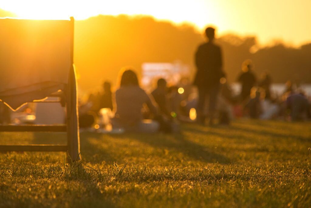 Ein sonniger Abend im Park mit Menschen auf einer Wiese