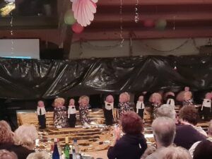 Ein Chor von älteren Damen in traditioneller Kleidung auf der Bühne