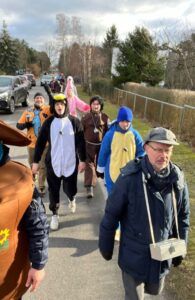 Ein Mann und mehrere Kinder in Kostümen gehen spazieren.