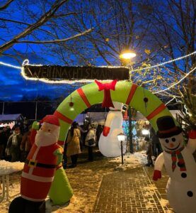 Ein Schneemann und ein Santa Claus neben einem weihnachtlichen Eingang.