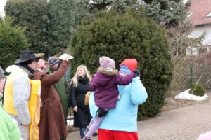 Ein Mann im Kostüm hält ein Kind auf dem Arm