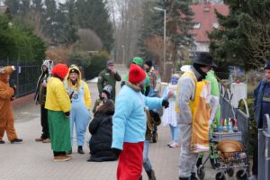 Menschengruppe in farbenfrohen Verkleidungen. Einige tragen Overalls und Mützen.